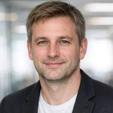 Man in his early 40s, dark-blonde hair, grey-green eyes, dark blazer